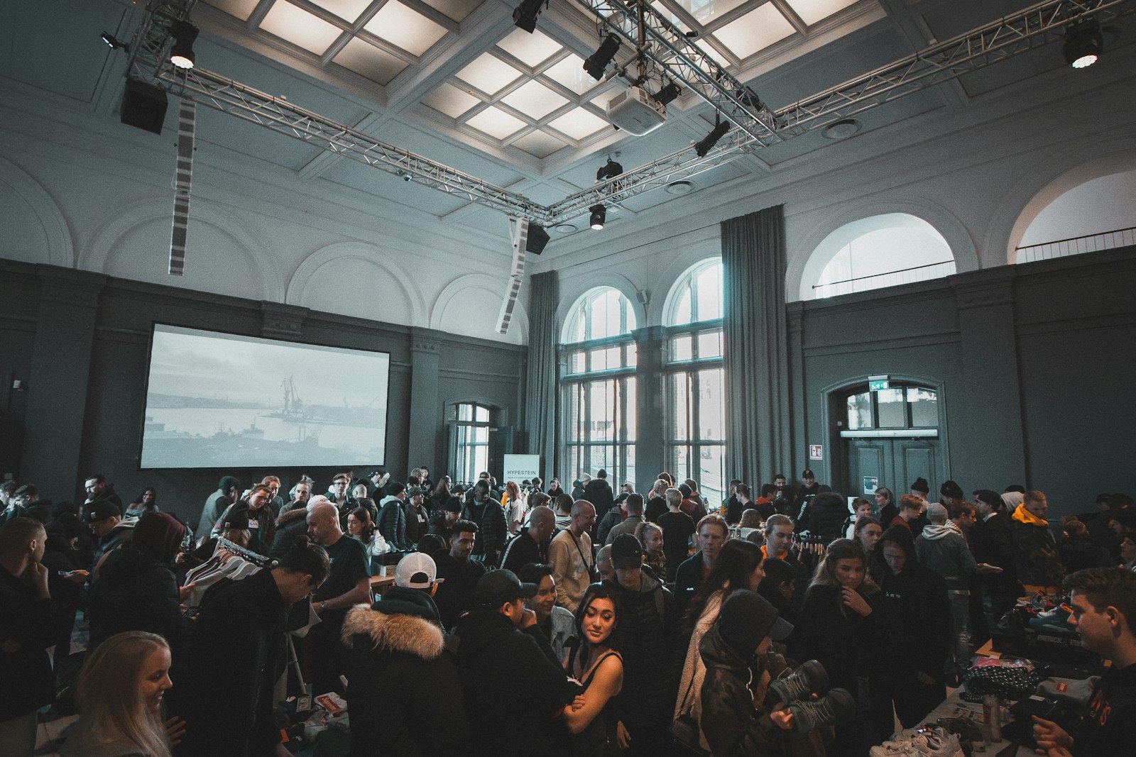 Grosser Saal mit über fünfzig Teilnehmenden an einem Business-Meeting